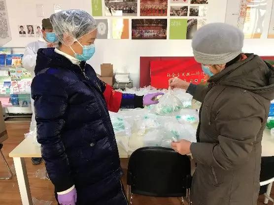 為樓棟分發(fā)口罩，并為包裝袋消毒